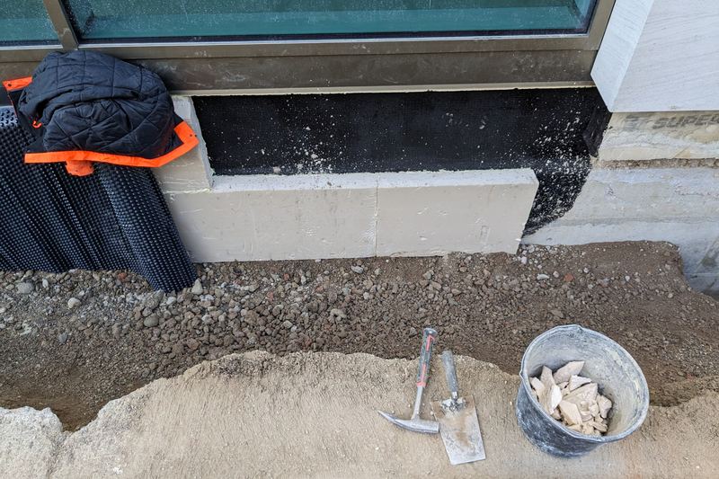 Dimpled membrane protecting an exterior basement wall against ground moisture